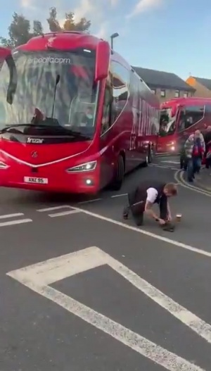 上嘴臉??利物浦大巴離開時，一名水晶宮球迷故意蹲在車前系鞋帶